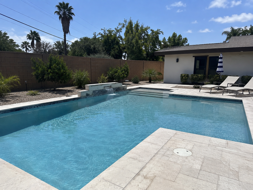 Pool remodeling in La Mesa with light stone decking, entry steps, and a small waterfall.